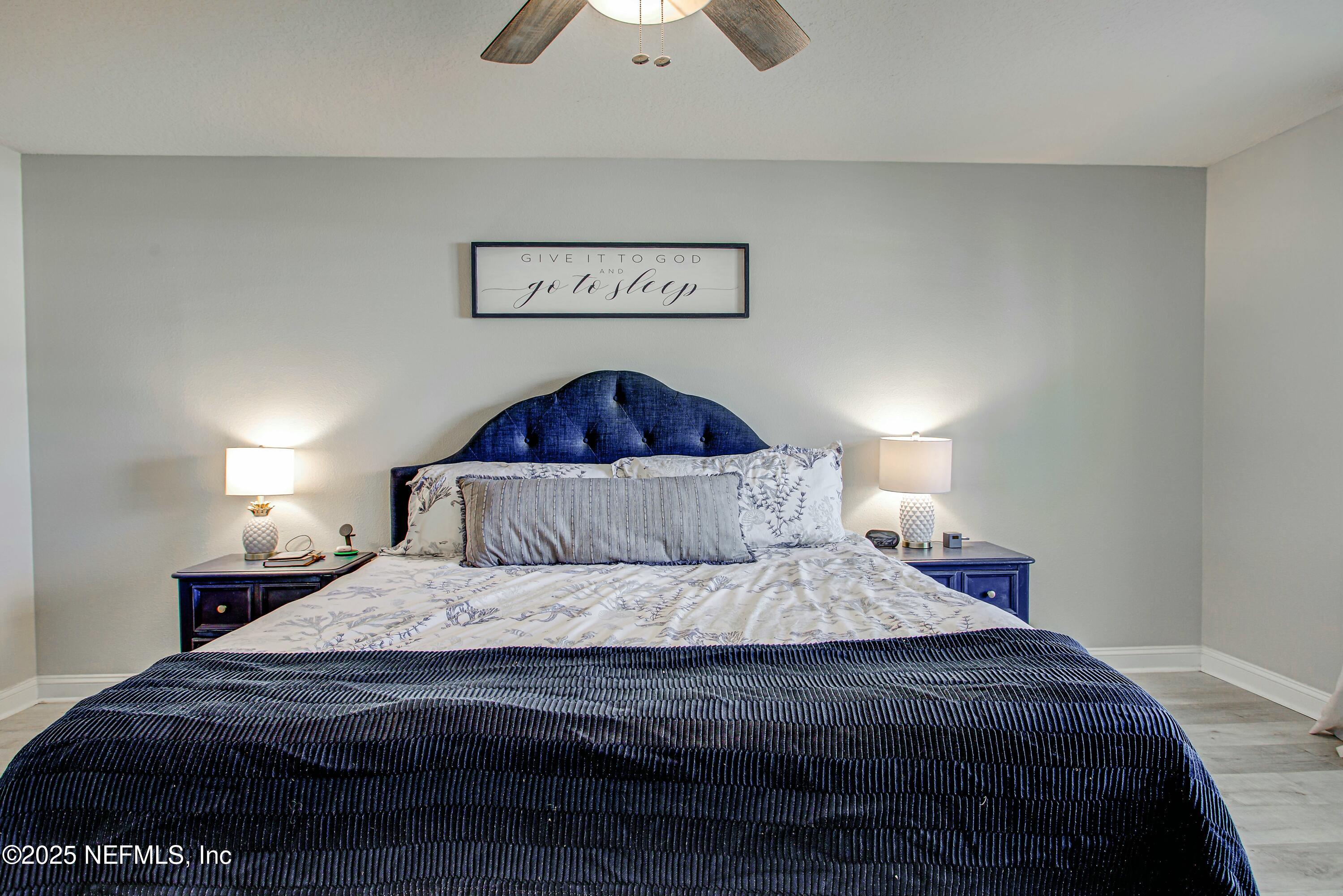 88083 Maybourne Road Yulee, FL 32097 - Photo 63 of 76 a bedroom with a bed and a chandelier