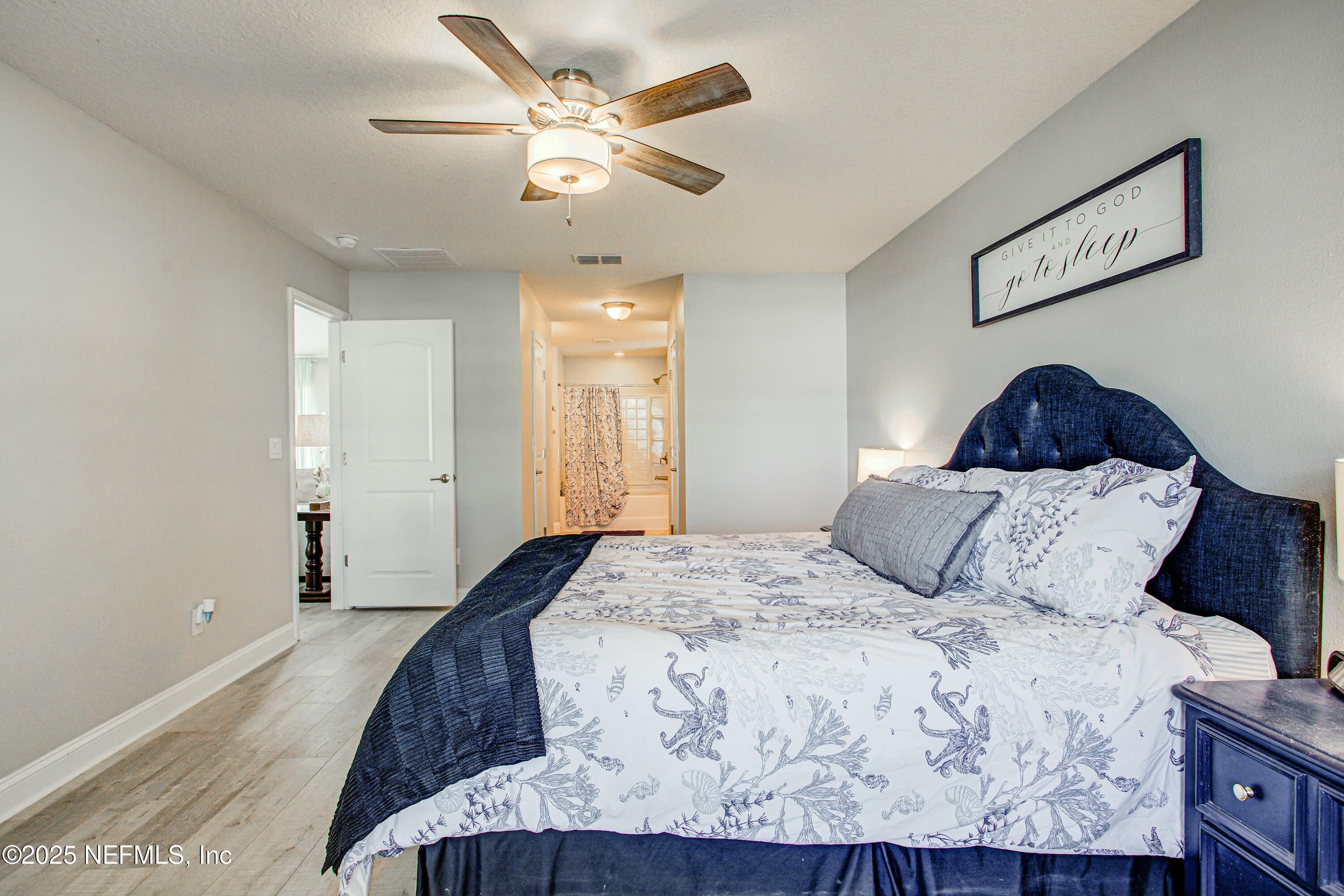 88083 Maybourne Road Yulee, FL 32097 - Photo 65 of 76 a bedroom with a large bed and a chandelier