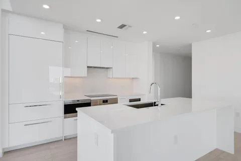 a kitchen with a sink a stove and cabinets