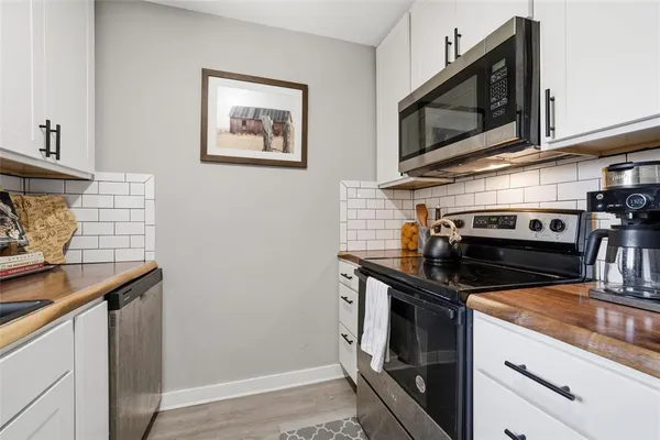 a kitchen with stainless steel appliances a stove a microwave and a sink