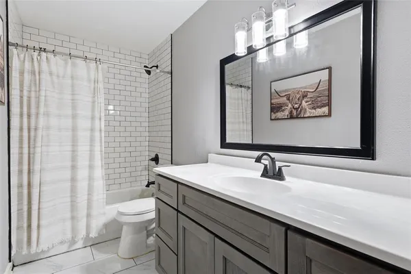 a bathroom with a sink a toilet and shower curtain