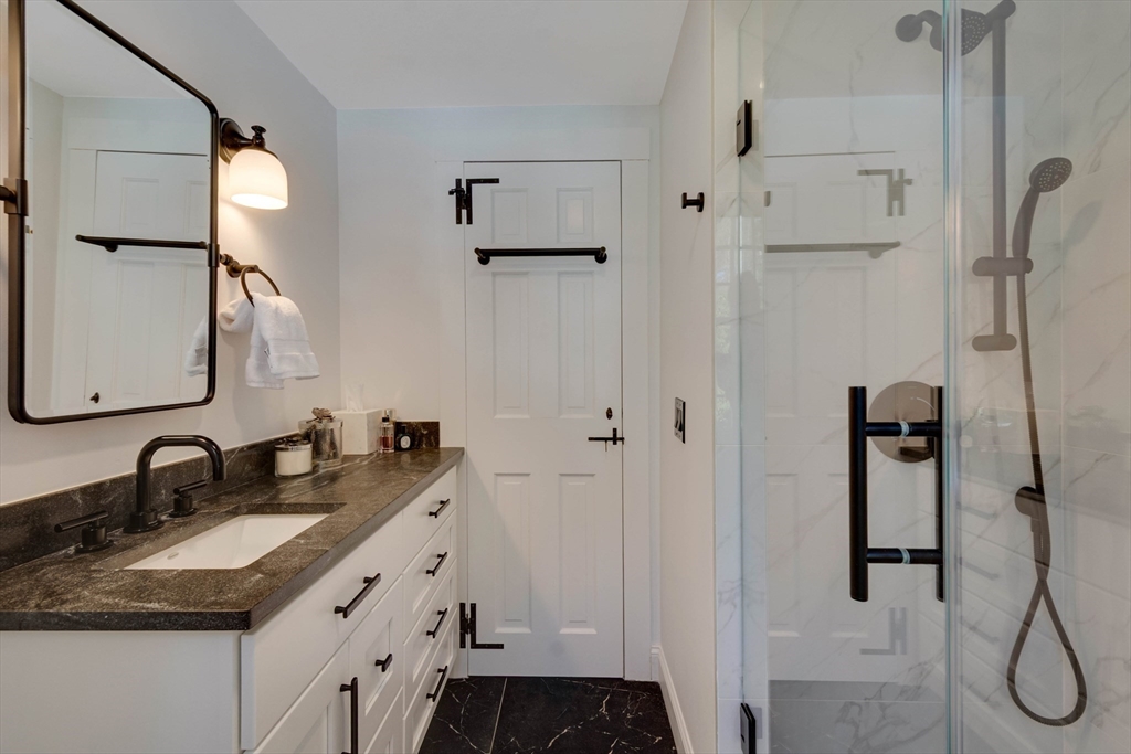 32 Pope Road Acton, MA 01720 - Photo 17 of 38 a bathroom with a granite countertop sink two mirror and shower