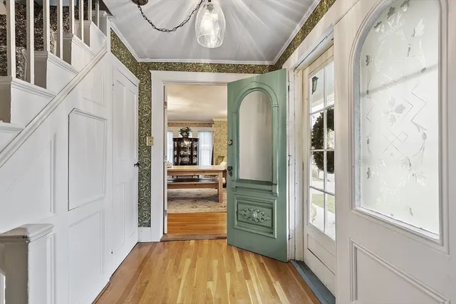 a view of a hallway with wooden floor and staircase
