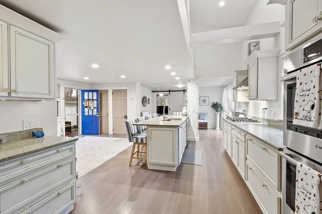 a large white kitchen with stainless steel appliances lots of counter top space