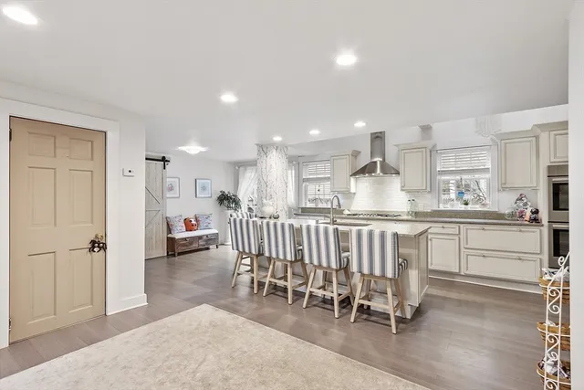 a kitchen with white cabinets and chairs