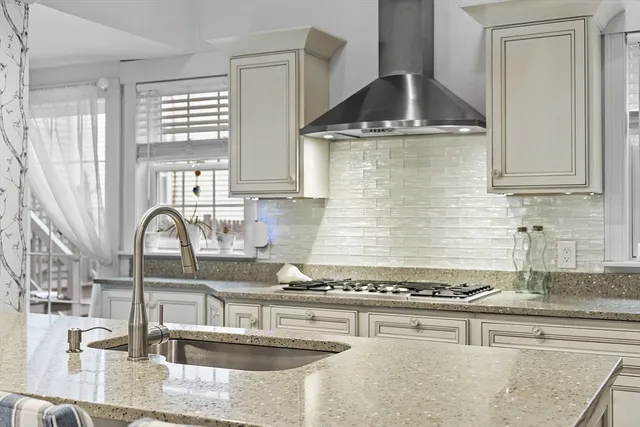 a kitchen with granite countertop a sink a stove and cabinets