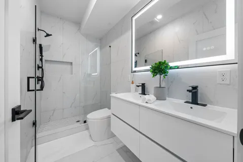 a bathroom with a sink a toilet and shower