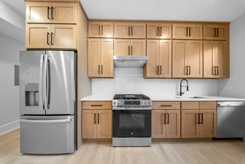 a kitchen with stainless steel appliances granite countertop a refrigerator a stove a sink and a microwave