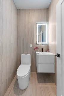 a bathroom with a sink mirror and toilet