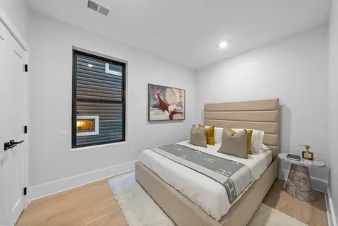 a bedroom with a bed and a painting on the wall