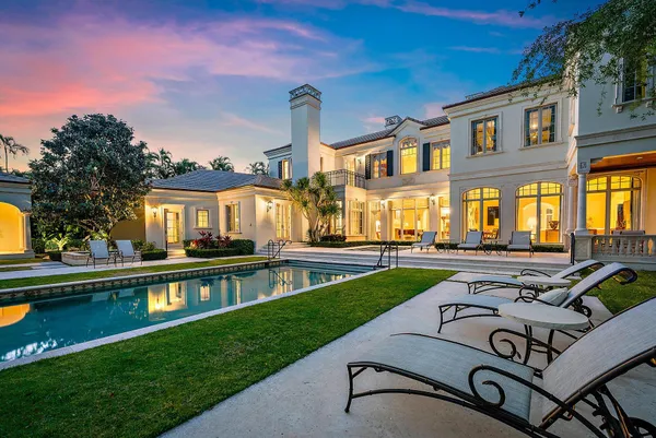 a view of a house with pool and chairs