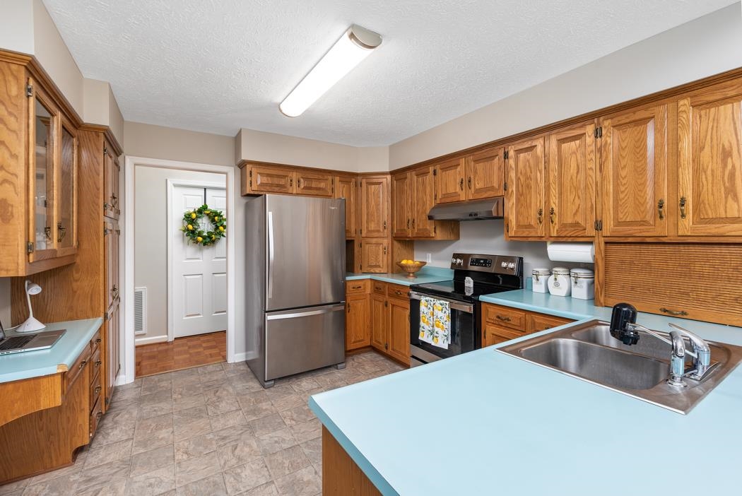 88 Cranberry Drive Stuarts Draft, VA 24477 - Photo 23 of 67 a kitchen with stainless steel appliances granite countertop a refrigerator a sink dishwasher a stove with wooden cabinets and floor