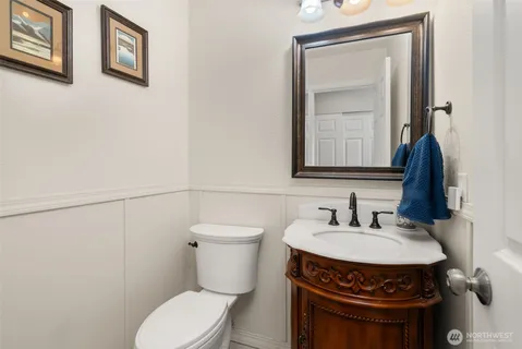 a bathroom with a toilet a sink and mirror