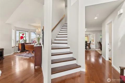 a view of a hallway with wooden floor and furniture