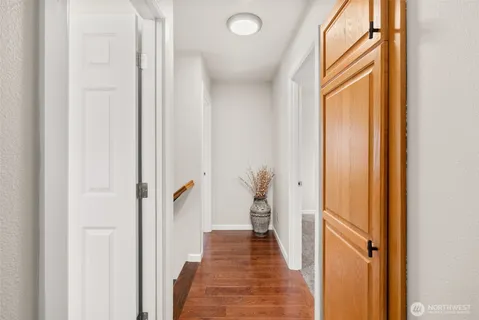 a view of a hallway with wooden floor and staircase