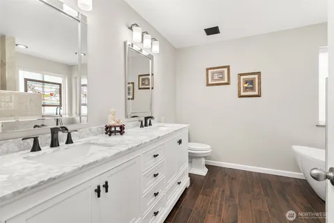 a bathroom with a double vanity sink toilet a mirror and shower