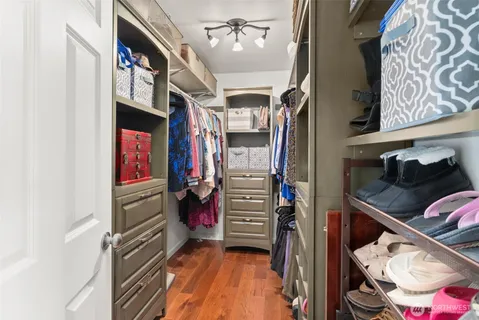 a view of walk in closet with clothes and shoes