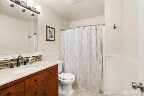 a bathroom with a sink a toilet and a mirror