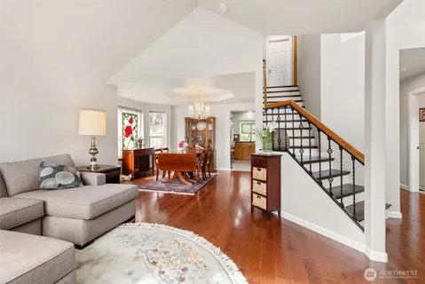 a living room with furniture and a dining table with wooden floor