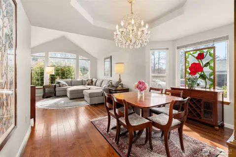 a view of a dining room with furniture a chandelier and wooden floor