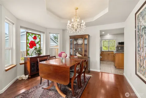 a view of a dining room with furniture a chandelier and wooden floor