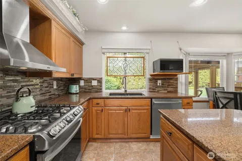 a kitchen with stainless steel appliances granite countertop a sink stove and refrigerator