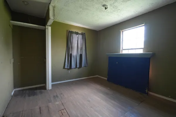 an empty room with windows and closet