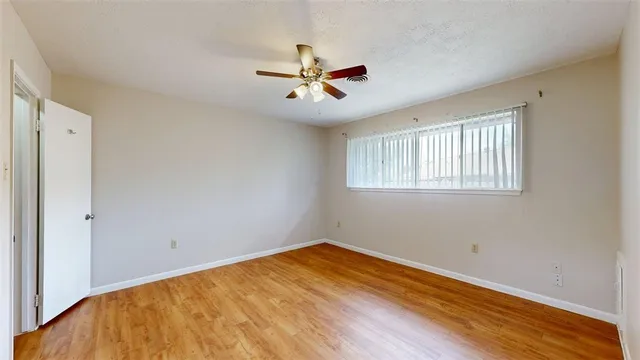 a view of empty room with wooden floor
