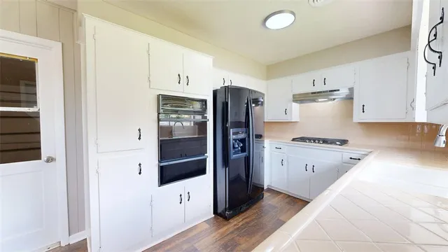 a kitchen with stainless steel appliances granite countertop a refrigerator and a stove