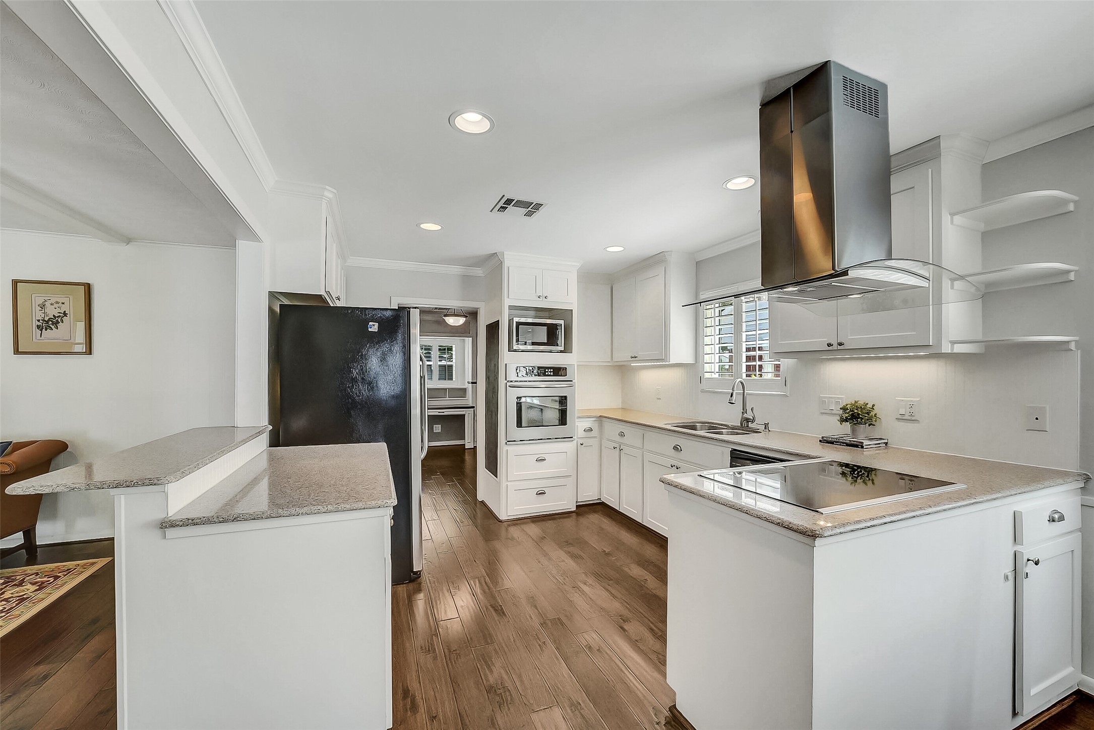 10026 Overbrook Lane Houston, TX 77042 - Photo 13 of 29 Renovated kitchen featuring silestone countertops, white beadboard backsplash and under cabinet lighting for both function and style. Equipped w/ a Bosch electric cooktop, stainless steel appliances, and a built-in magnetic chalkboard. Seamless connection to the study enhances the home’s flexible layout.