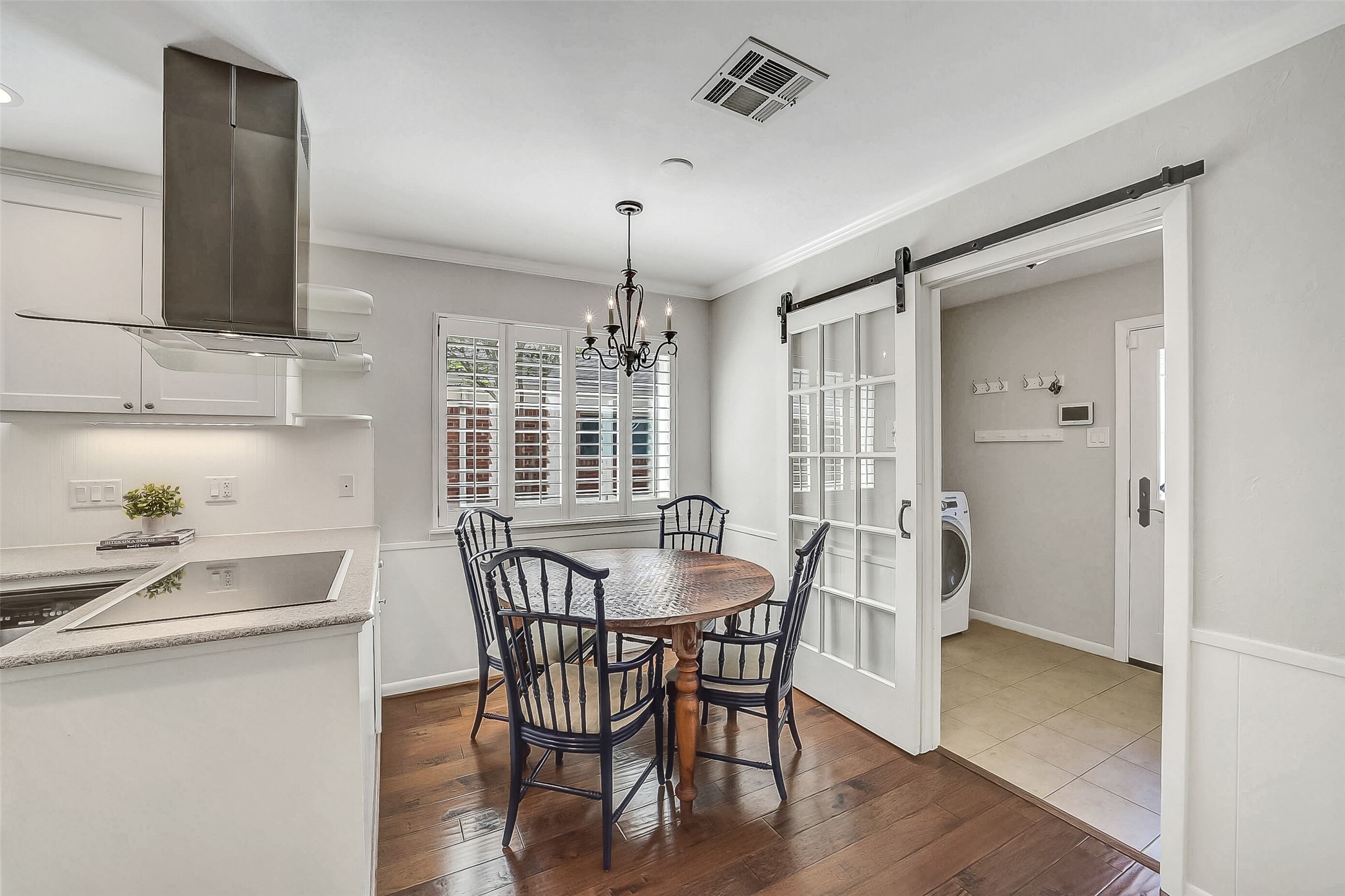 10026 Overbrook Lane Houston, TX 77042 - Photo 17 of 29 Bright and inviting breakfast area features a decorative light fixture and updated windows (2025) w/ plantation shutters. Open to both the kitchen and family room, this space offers an ideal setting for everyday dining while maintaining a seamless, connected flow. Sliding door to the right leads to the utility room.