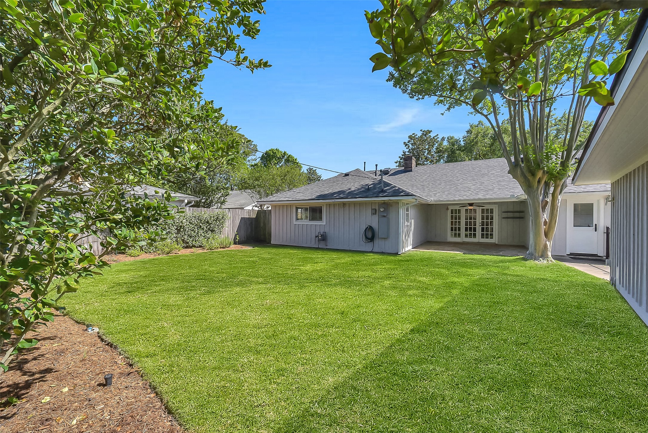 10026 Overbrook Lane Houston, TX 77042 - Photo 27 of 29 Spacious backyard offering a large greenspace ideal for pets, play, or outdoor enjoyment. Fully equipped w/ sprinkler system and surrounded by a well-maintained fence (approx. 6 years old), creating both functionality and privacy.