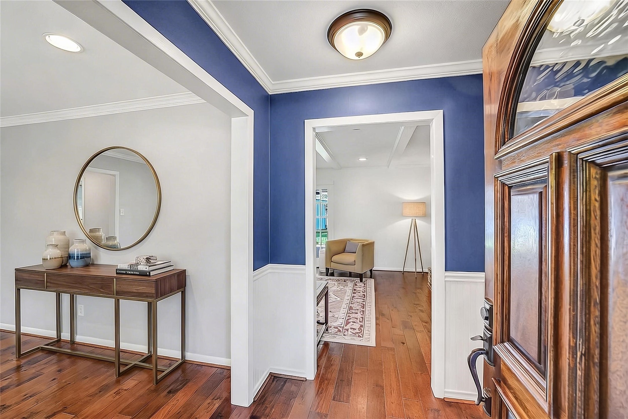 10026 Overbrook Lane Houston, TX 77042 - Photo 5 of 29 As you walk into the entry, you will notice the navy accent painted walls paired w/ classic wainscoting adding depth and character, complemented by an updated light fixture. To the left leads to the formal living/dining. Straight ahead leads to the family room. Hallway to the right when you walk in leads to three closets and attic access, offering exceptional functionality and storage. This photo is virtually staged.