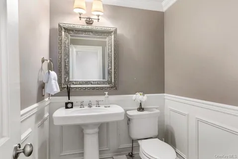 a bathroom with a toilet sink and mirror