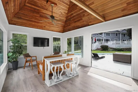 a view of a patio with table and chairs potted plants with wooden floor