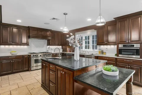 a kitchen with kitchen island granite countertop a sink counter and cabinets