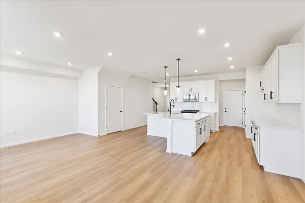 a large white kitchen with a large counter top appliances and cabinets