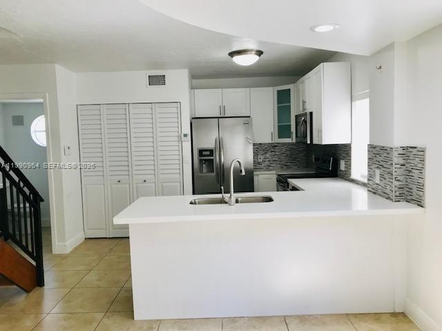 3356 Bird Avenue, Unit 10 Miami, FL 33133 - Photo 3 of 25 a kitchen with stainless steel appliances kitchen island wooden cabinets and a sink