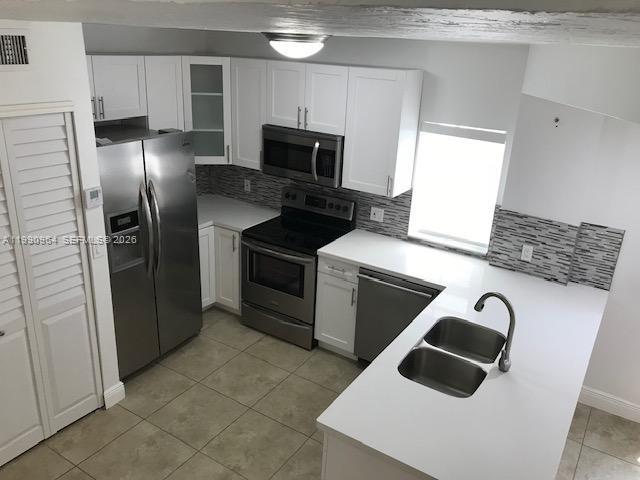 3356 Bird Avenue, Unit 10 Miami, FL 33133 - Photo 10 of 25 a kitchen with stainless steel appliances kitchen island granite countertop a refrigerator stove and sink