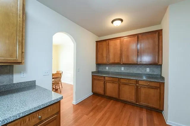 a view of kitchen with granite countertop cabinets and wooden floor