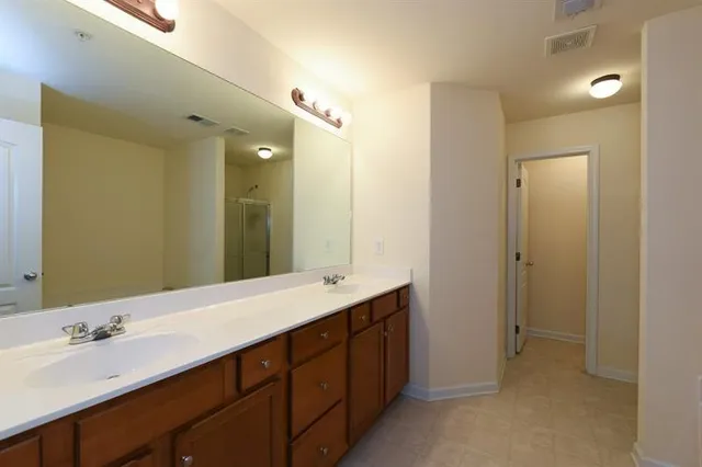 a bathroom with a double vanity sink and mirror