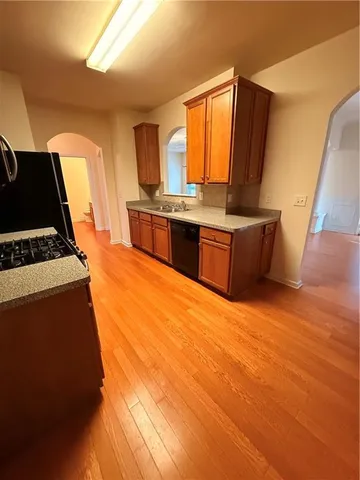 a view of a room with wooden floor a ceiling fan and fireplace