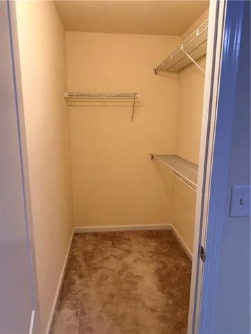a view of walk in closet with empty racks