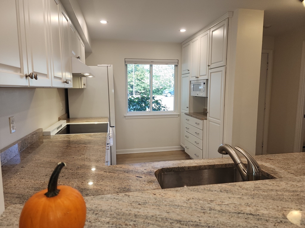 17 Beal's Cove Road, Unit A Hingham, MA 02043 - Photo 7 of 31 a view of a kitchen with a sink stainless steel appliances and cabinets