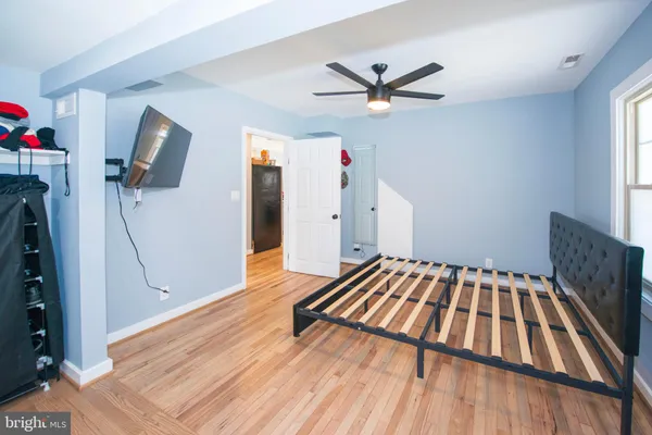 a bedroom with a bed and wooden floor