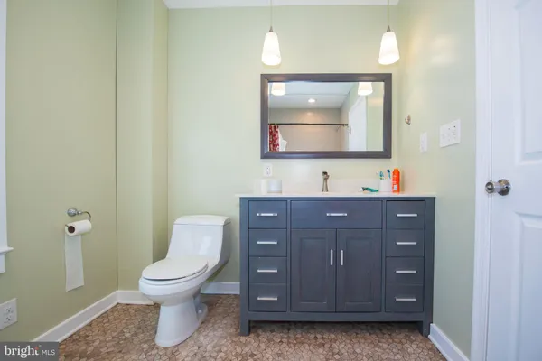 a bathroom with a toilet sink vanity and mirror