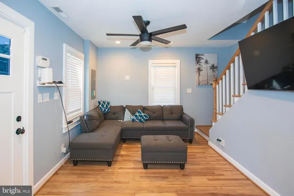 a living room with furniture and a wooden floor