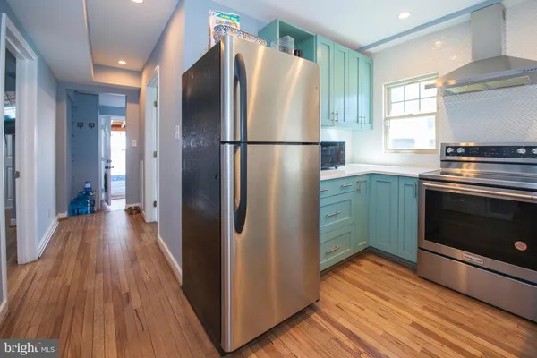 a kitchen with stainless steel appliances granite countertop a refrigerator and a stove top oven