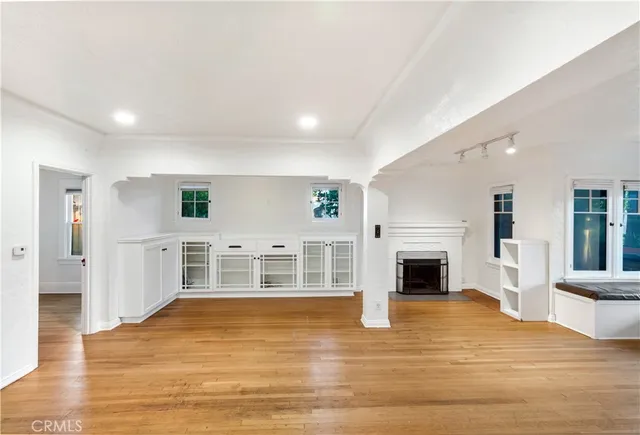 a view of empty room with wooden floor and fireplace