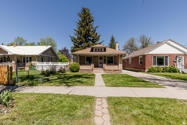 365 West 200 North Logan, UT 84321 - Photo 45 of 45 Craftsman-style home featuring a gabled roof, prominent brick porch columns, and a front yard with mature landscaping
